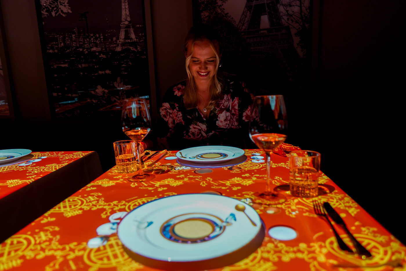 Guest enjoying the 3D table projection with a Paris skyline backdrop